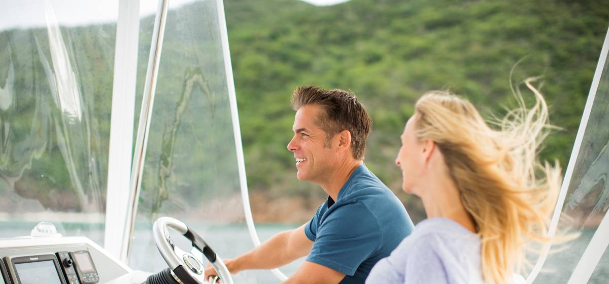 Couple enjoying the wind in their hair while cruising on a power catamaran